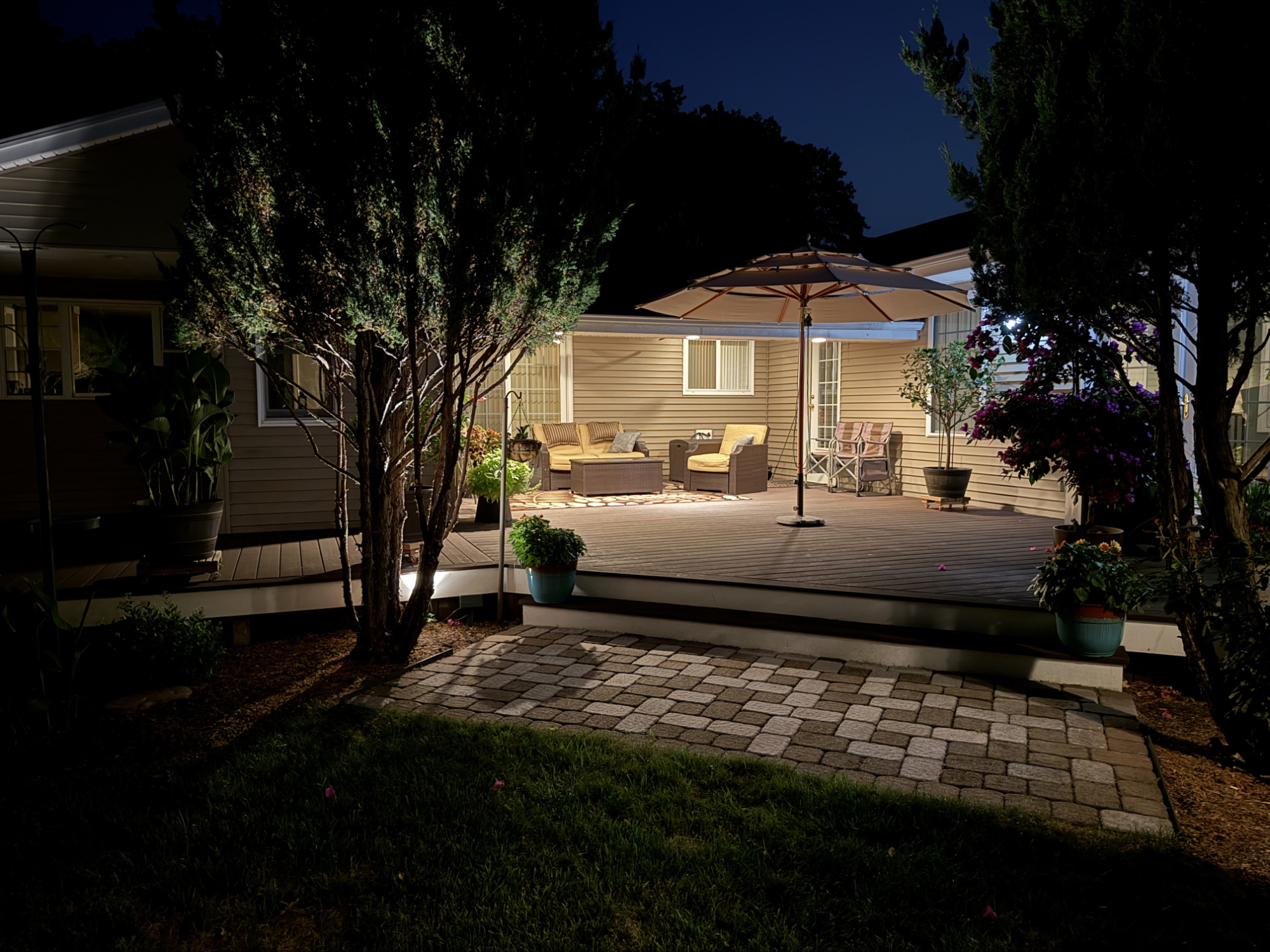Evening view of lighted covered deck and outdoor seating area