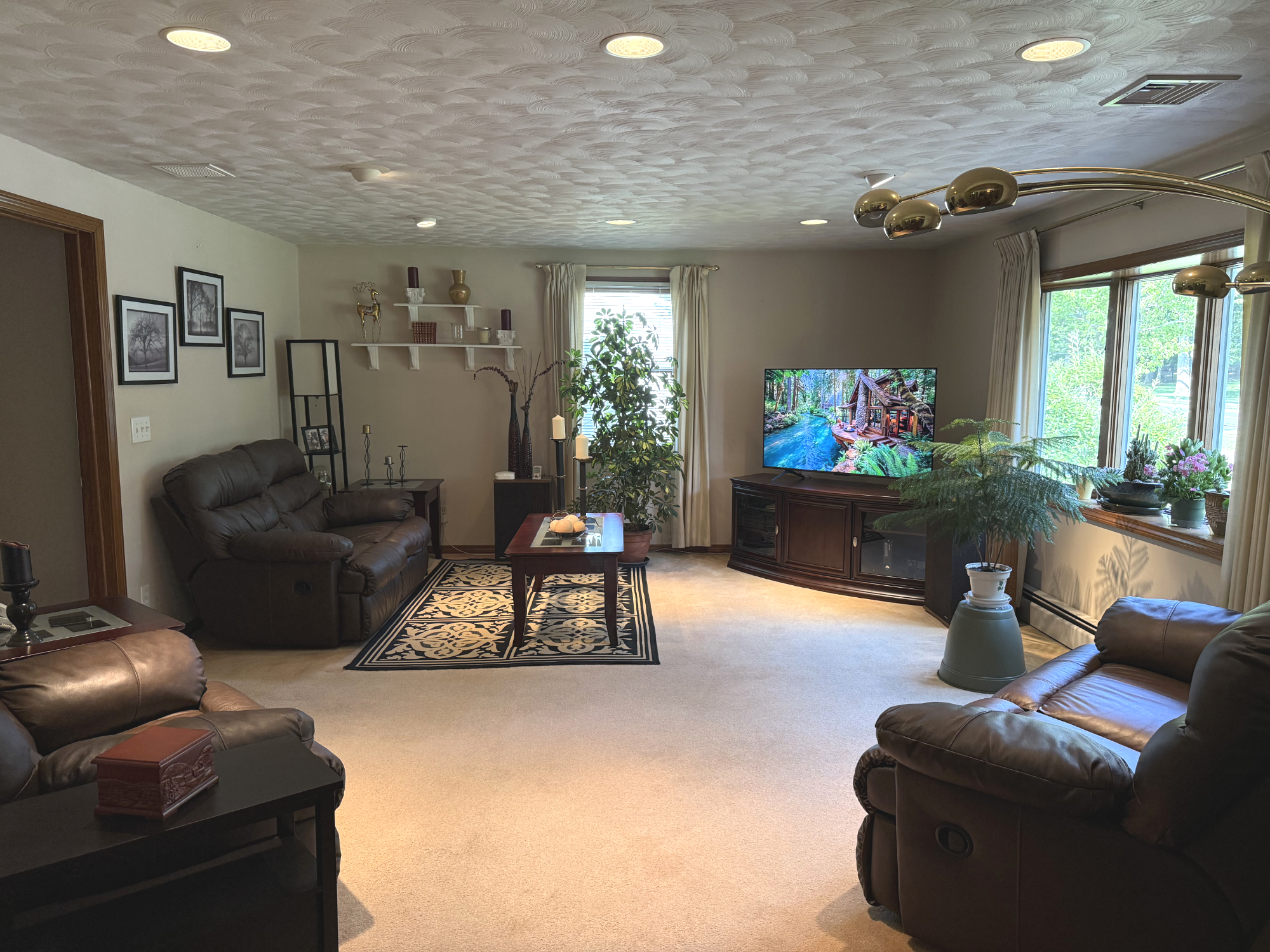 Bright furnished living room with leather seating and a large television
